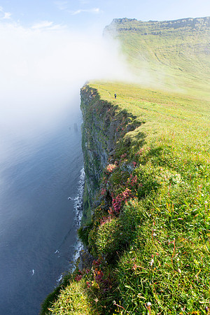 Corrie hiking the Horn as clouds roll over the edge (portrait)