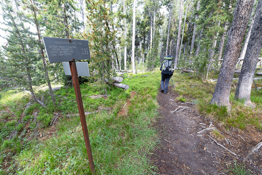 Backpacker at North-South Shore Shoshone Lake Trail junction