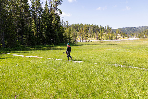 Hiker on foot bridge to enter Shoshone Geyser Basin