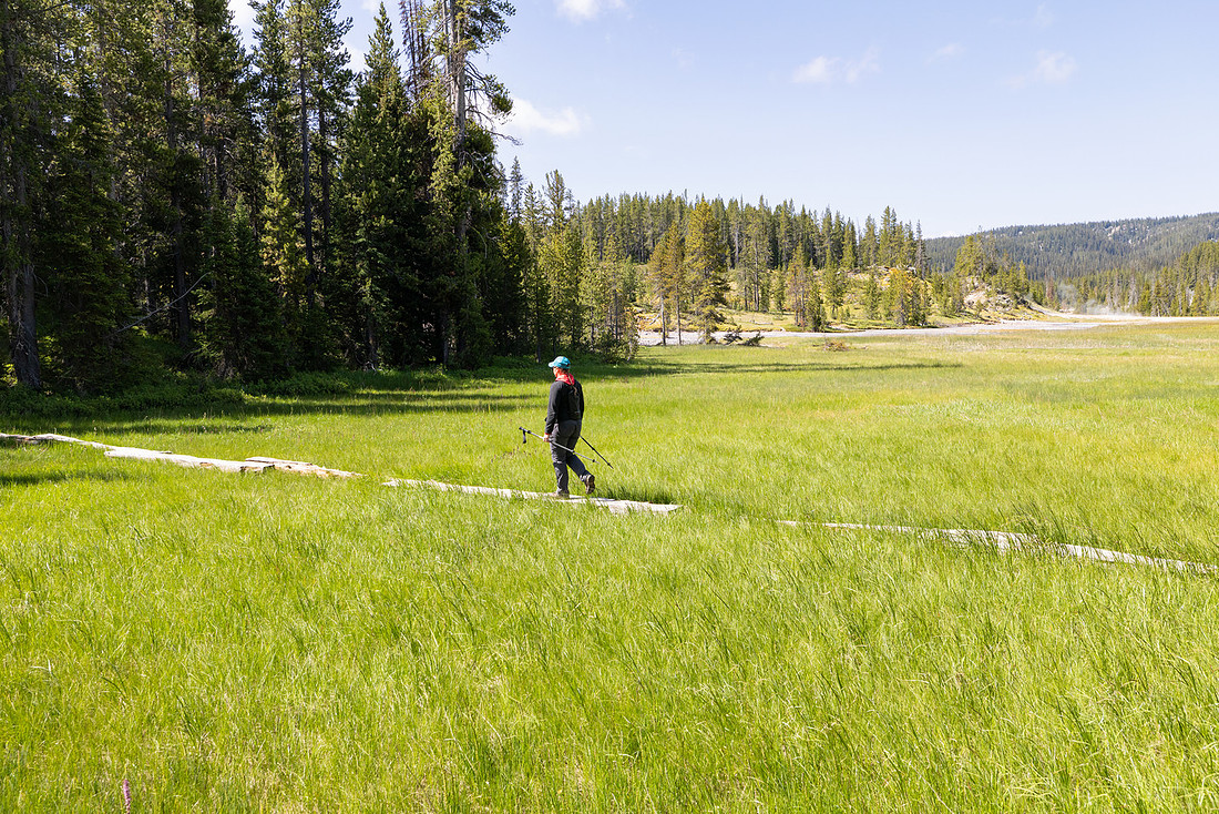 Hiker on foot bridge to enter Shoshone Geyser Basin